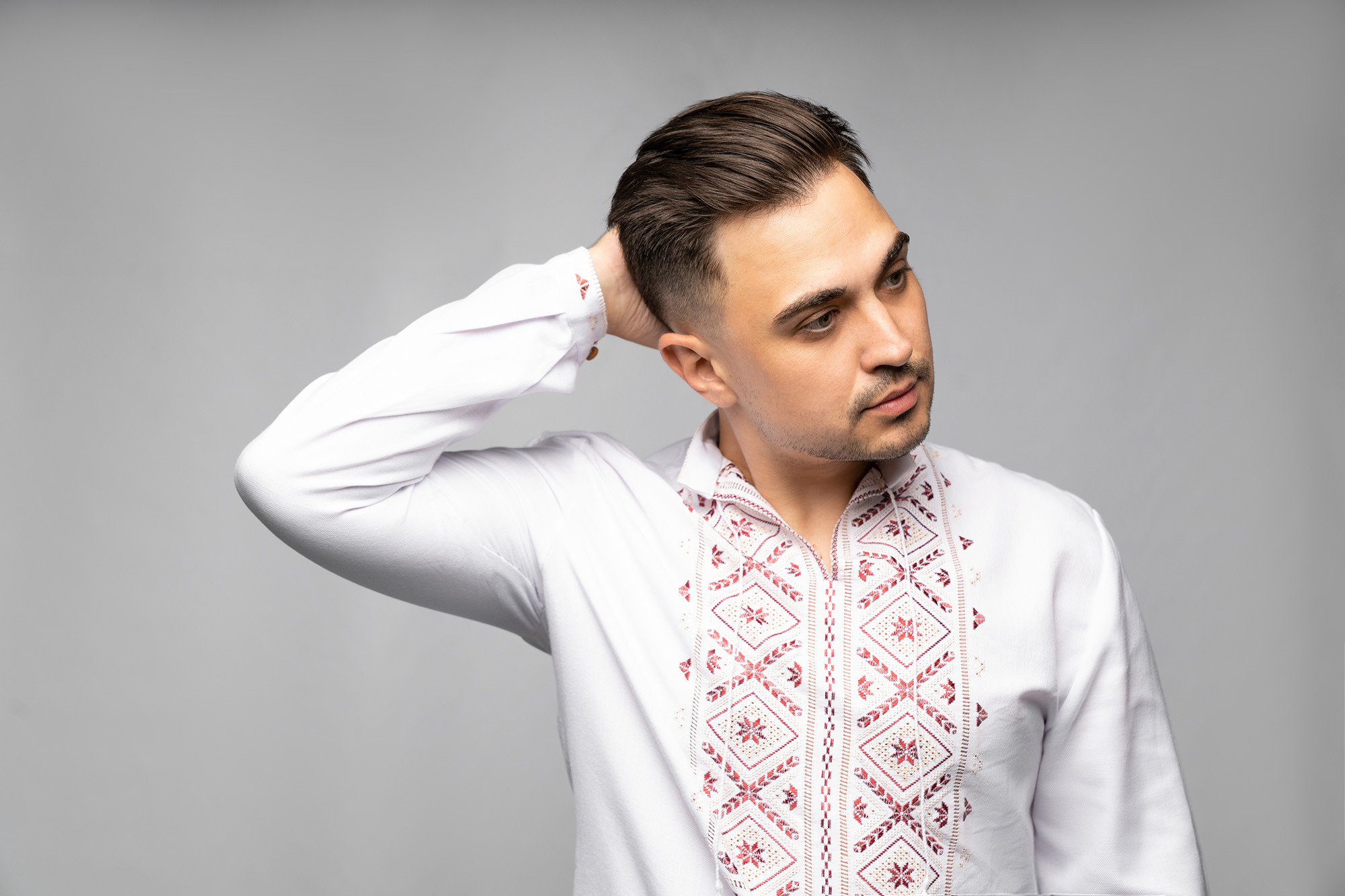 Хлопець в українській вишиванці поправляє зачіску