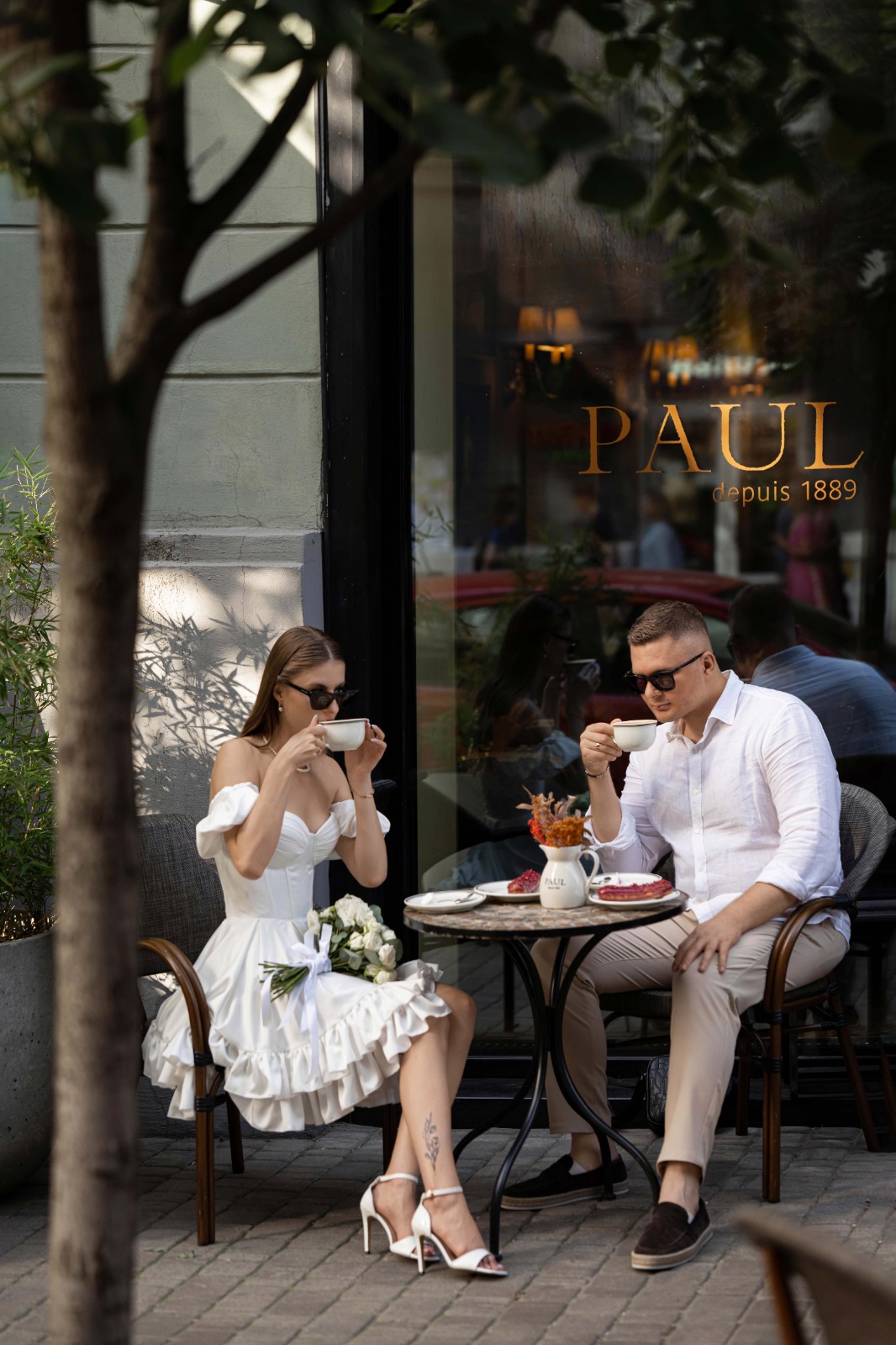 Весільний пара п'є каву на веранді кафе Paul після церемонії