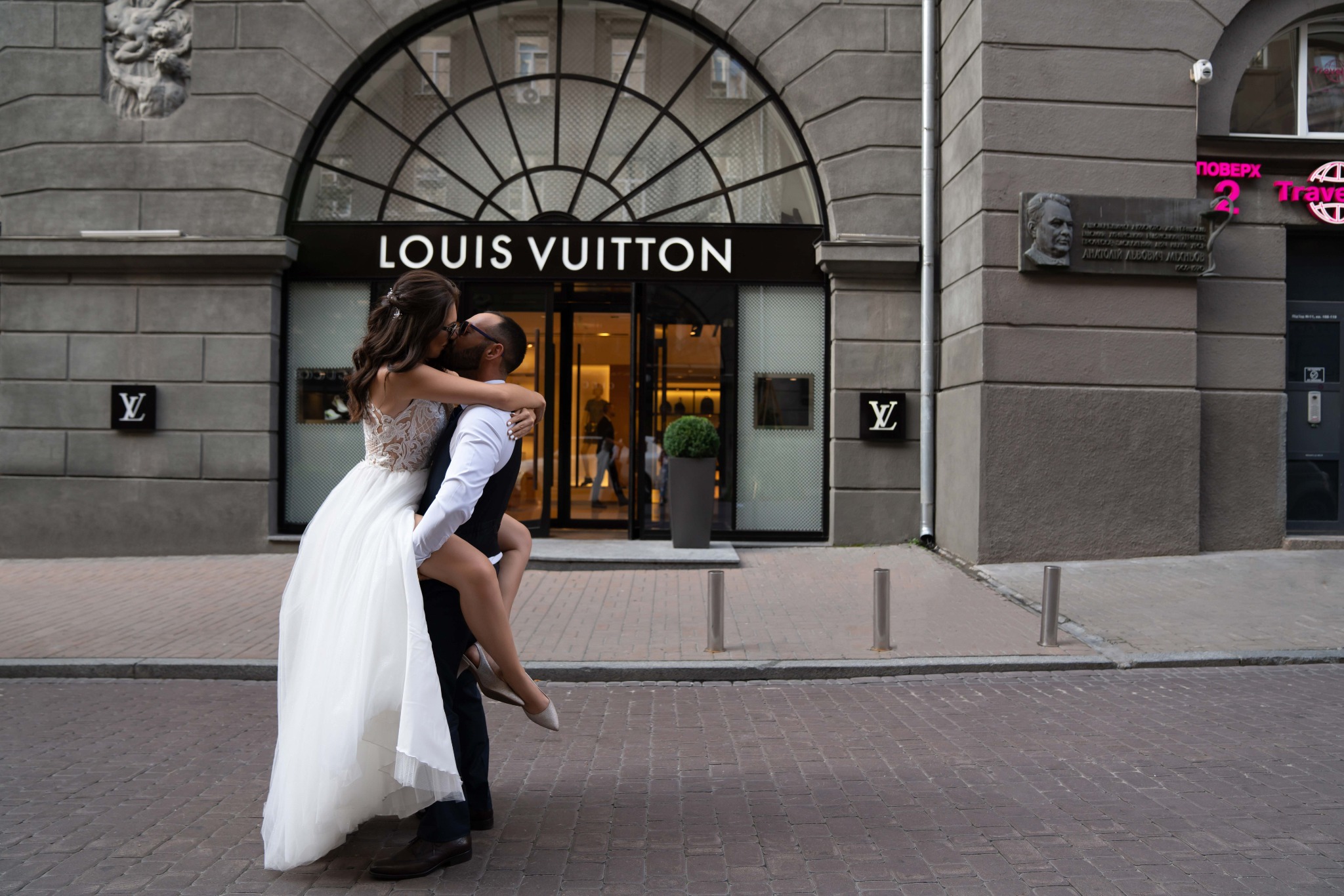 Романтичний поцілунок пара на фоні бутика Louis Vuitton