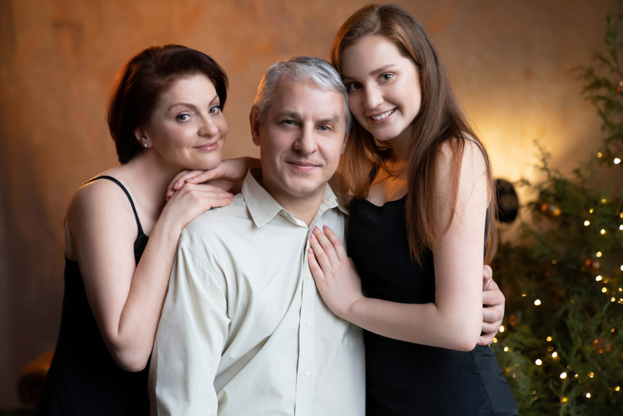 Сімейний портрет з ялинкою у затишній різдвяній атмосфері.