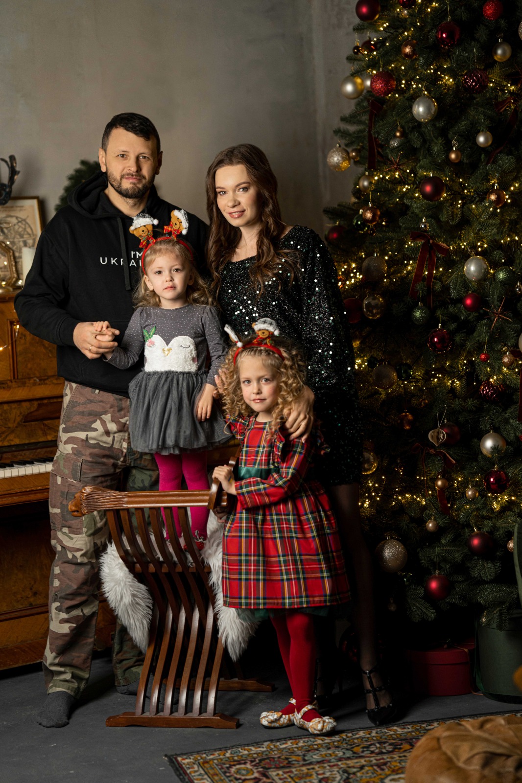 Сімейна новорічна фотосесія біля ялинки з дітьми у святковому вбранні
