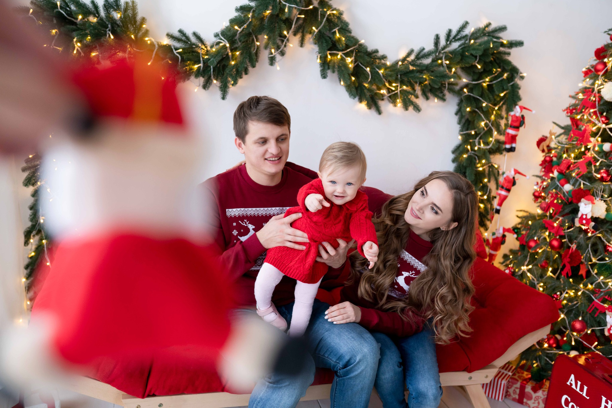 Сімейна новорічна фотосесія з малюком біля ялинки та гірлянд