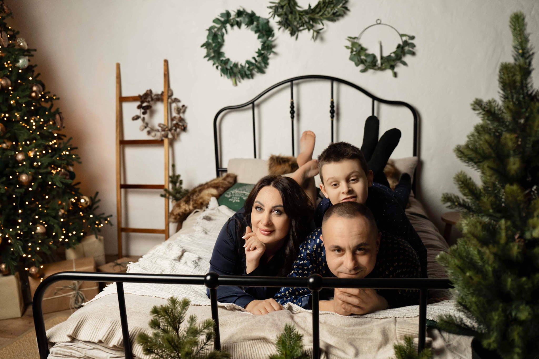 Сімейна фотосесія у затишній спальні з новорічним декором та гірляндами